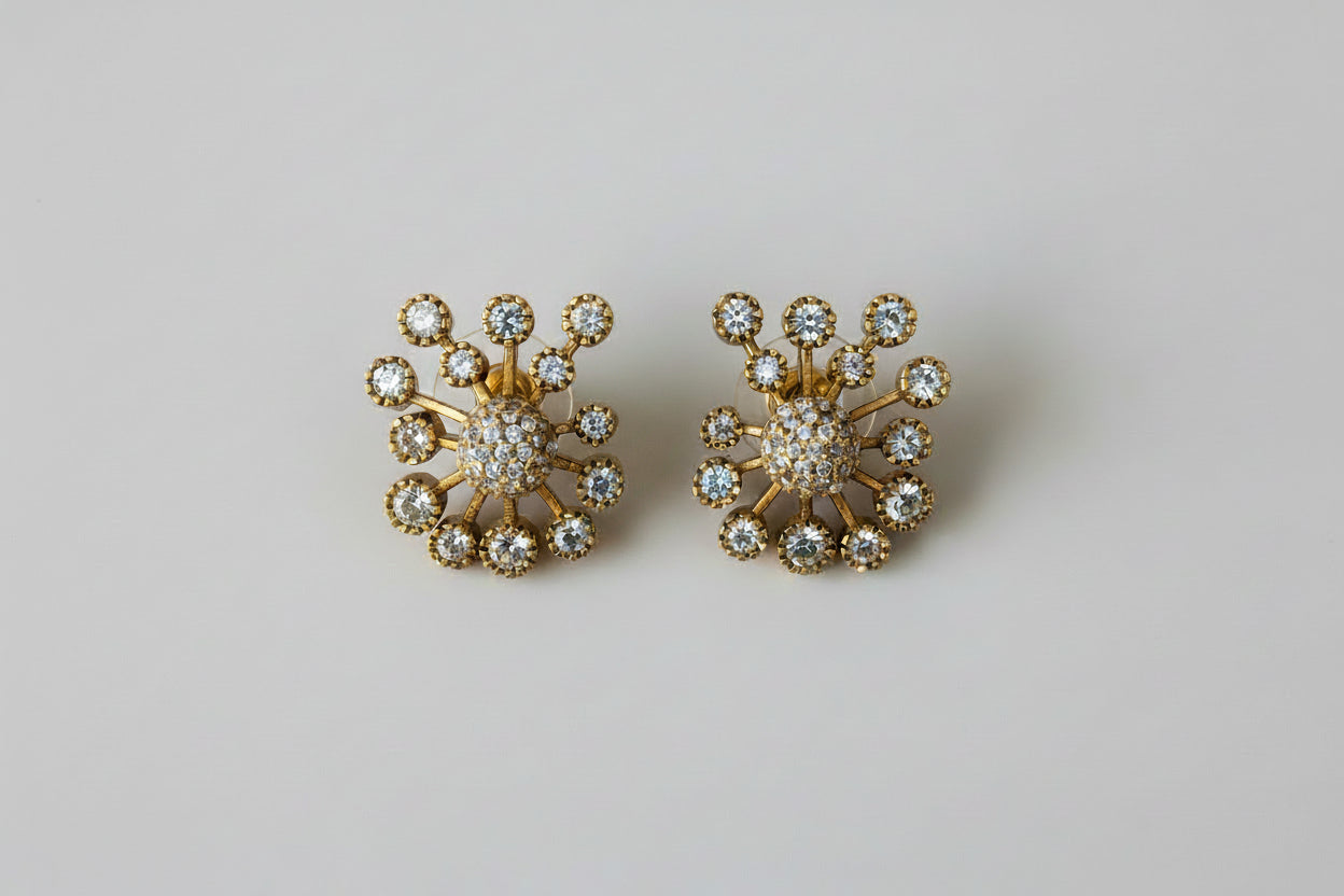 Gold earrings with gemstones on a light background