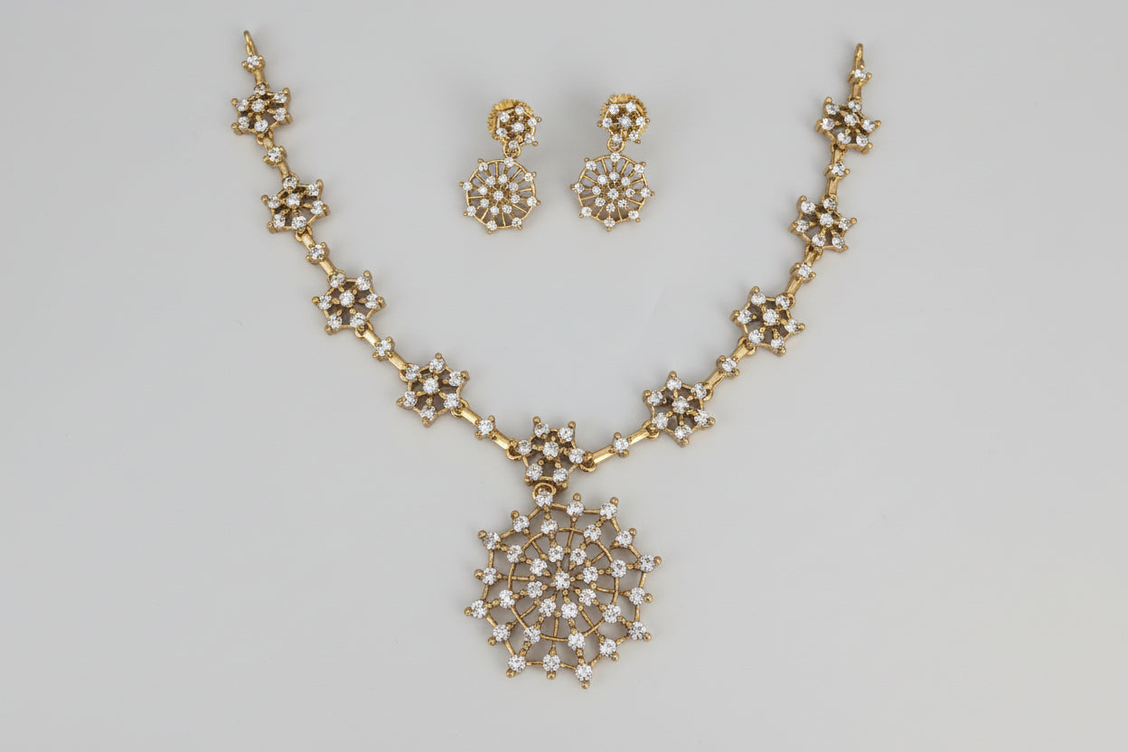 Gold necklace and earrings set on a white background